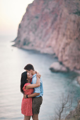 Fototapeta premium Young Stylish Couple in Love Walking in Mountains by the Sea. Vine Sunset Summer Mood
