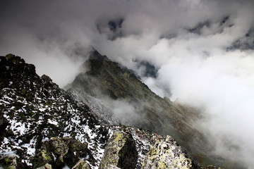 View from Slavkovsky peak, High Tatras, Tatra National Park, Slovakia, to the cloud covered Velka Studena Dolina valley and sharp edge ridge towards the subpeak Slavkovska Kopa.
