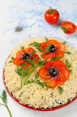 Salad decorated with poppies made of sliced tomatoes and olives