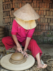 A local Vietnam woman manufacturing bowls on pottery wheal. Than Ha pottery village. Vietnam, March...