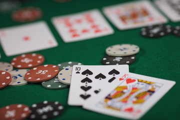 Poker game in men's hands on green table
