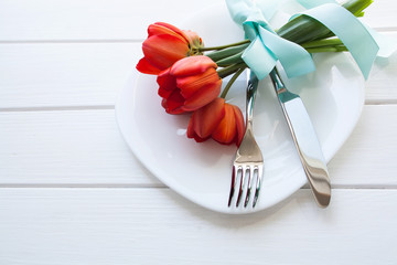 Tulips on a plate on a wooden white table