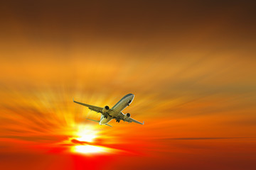 Fototapeta na wymiar Airplane on sunrise background