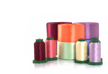 Threads for embroidery, satin ribbons, sewing thread and needlework on a white background