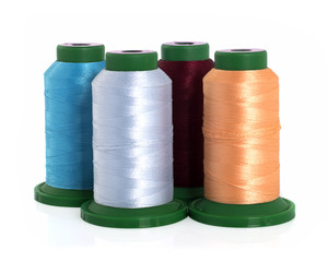 Colored threads on reels on a white background