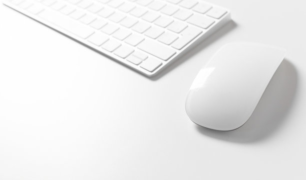 Computer keyboard and mouse on top of white desktop