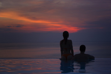 Man and woman at sunset by the sea.