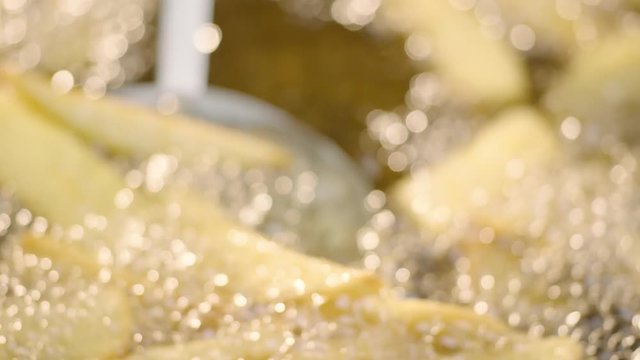 Fried potatoes. Potatoes fried in oil. French fries. Take to the potatoes in the fried with perforated ladle. Close-up shooting. High quality. Alexa Camera