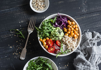 Quinoa and spicy chickpea vegetable vegetarian buddha bowl. Healthy food concept. On a dark background, top view