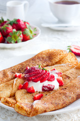 closeup of pancakes with strawberry on plate on dark wooden background