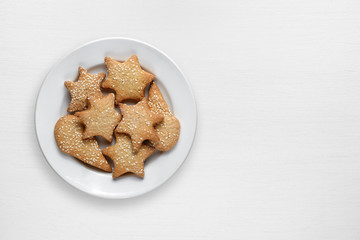 Cookies with sesame in plate on white wooden table