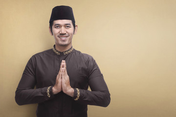 Handsome asian muslim man wearing traditional dress praying