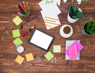 Creative office supplies and tablet on wooden background