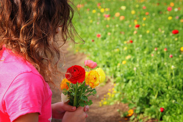 Cute kid holding bouquet of spring flowers