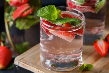 Detox water with fresh mint and strawberries in transparent glasses