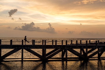 Fototapeta na wymiar siluate picture women walking on the bridge when sunset time, filling sad or alone