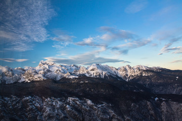 beautiful alpine chain of snowy mountains of julian alps in sunset blue sky, bohinj, slovenia
