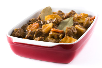 Beef meat stewed with potatoes, carrots and spices in ceramic pot isolated on white background

