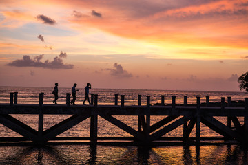 Fototapeta na wymiar siluate picture 3 man walking on the bridge when sunset time