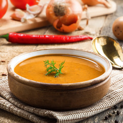Lentil soup in a rustic bowl on a cotton canvas tablecloth. Healthy vegetarian food on an old wooden table.