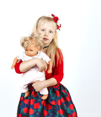 Little happy girl playing a doll, on a white