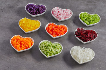 Obraz na płótnie Canvas Heart-shaped bowls with grated vegetables