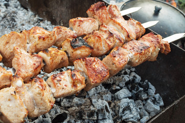 juicy fried meat on skewers outdoors