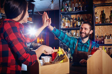 Barman and  waiter teamare working together at the bar.