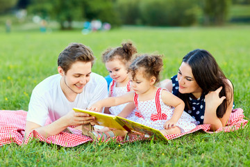 A happy family is reading book in the park