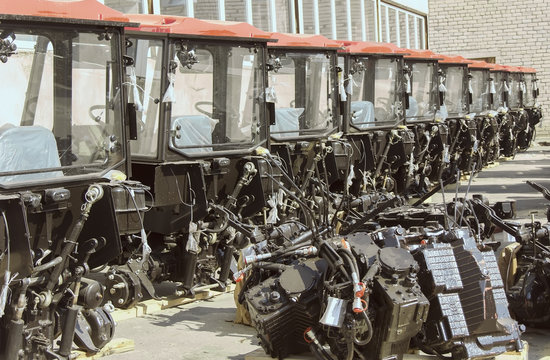 Harvesters and harvester parts at the plant are waiting for assembly, tractors and agricultural machinery
