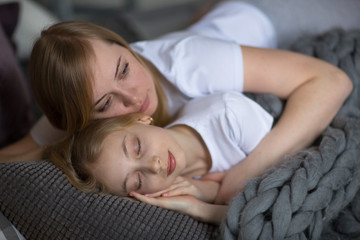 Mum embraces a sleeping daughter teenager