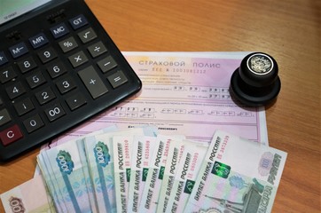 На столе в кабинете лежит страховой полис нового образца ,  ручка, печать предприятия, калькулятор и деньги –купюры монеты РФ 