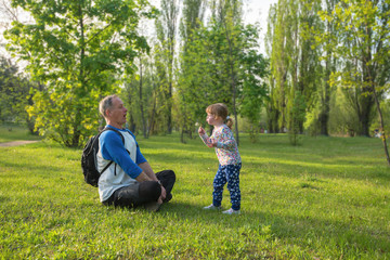 Naklejka na ściany i meble Father and daughter are playing in the park