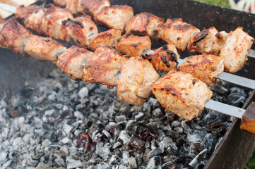 juicy fried meat on skewers outdoors