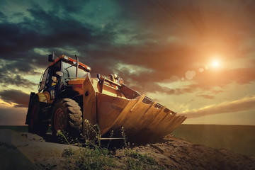 Yellow tractor on sky background