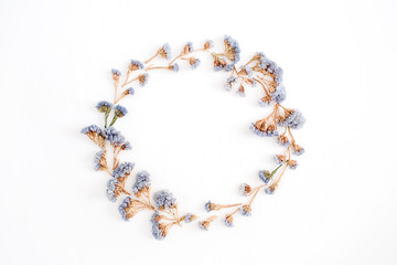 Frame wreath of pale blue dried flowers on white background. Flat lay, top view