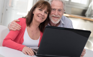 Fototapeta na wymiar Happy mature couple using laptop