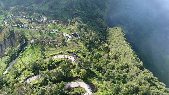 Aerial view flight over Cemoro Lawang, small village in morning mist. Which situated on the edge of massive north-east of Mount Bromo, East Java, Indonesia