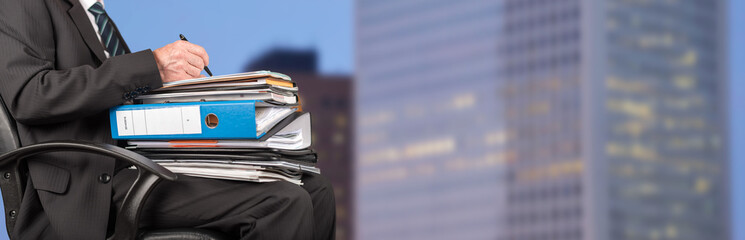 Businessman working with folders on his lap