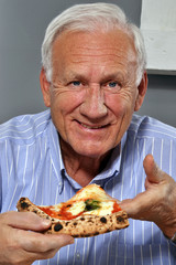 Abuelo feliz comiendo pizza. El anciano come pizza. - obrazy, fototapety, plakaty