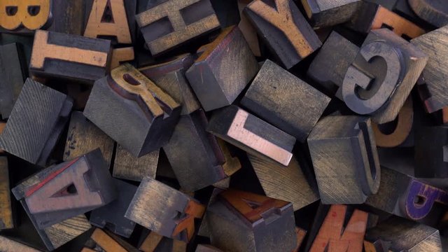 Vintage letterpress wood type printing blocks stained by color inks rotating background