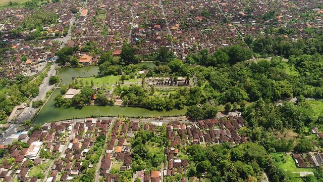   Aerial view in Bali Indonesia : Long. orderly row of structures with tiered. thatched roofs at Pura Taman Ayun. the royal Hindu temple complex in Bali. Indonesia.