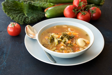 Bowl of soup Minestrone. Food background. Dark blue structural background. Italian Cuisine 
