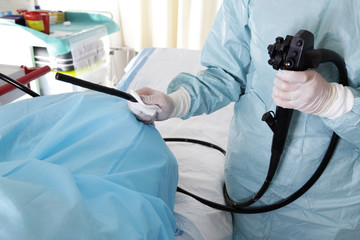 Lekarz trzyma głowicę operacyjną kolonoskopu  - obrazy, fototapety, plakaty