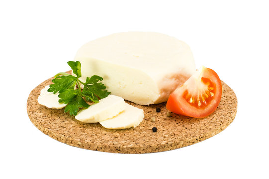 Сыр, помидор и петрушка на подложке на белом фоне
