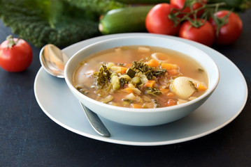 Bowl of soup Minestrone. Food background. Dark blue structural background. Italian Cuisine 
