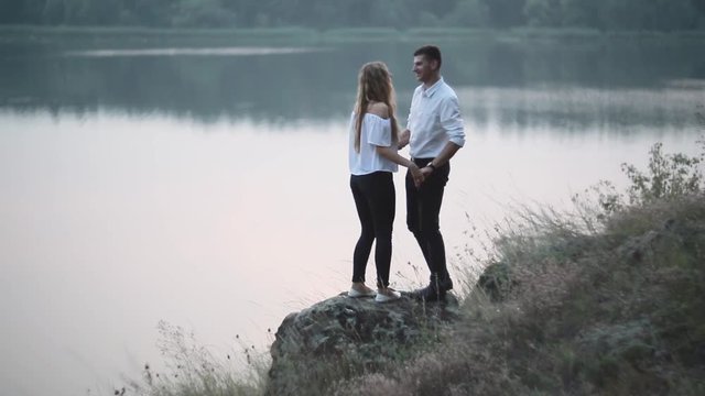 Young Couple Walk To River Bank