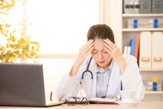 Woman doctor stressed with headache