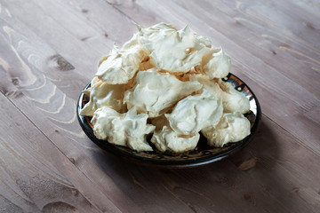 clay dish with meringue on wooden table