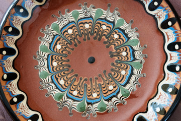 the ornament on the round clay plate closeup